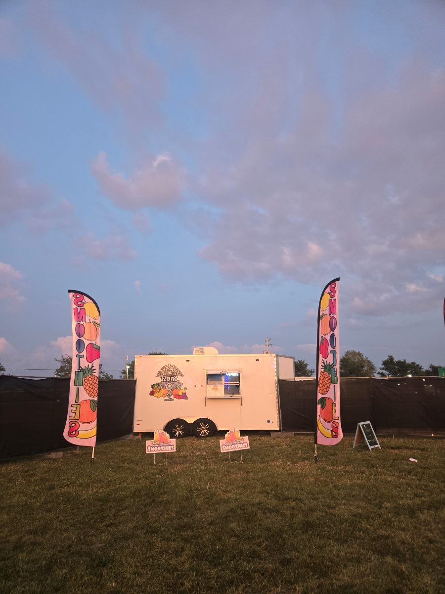 Thee Smoothie Kort trailer at sunset with branded feather flags